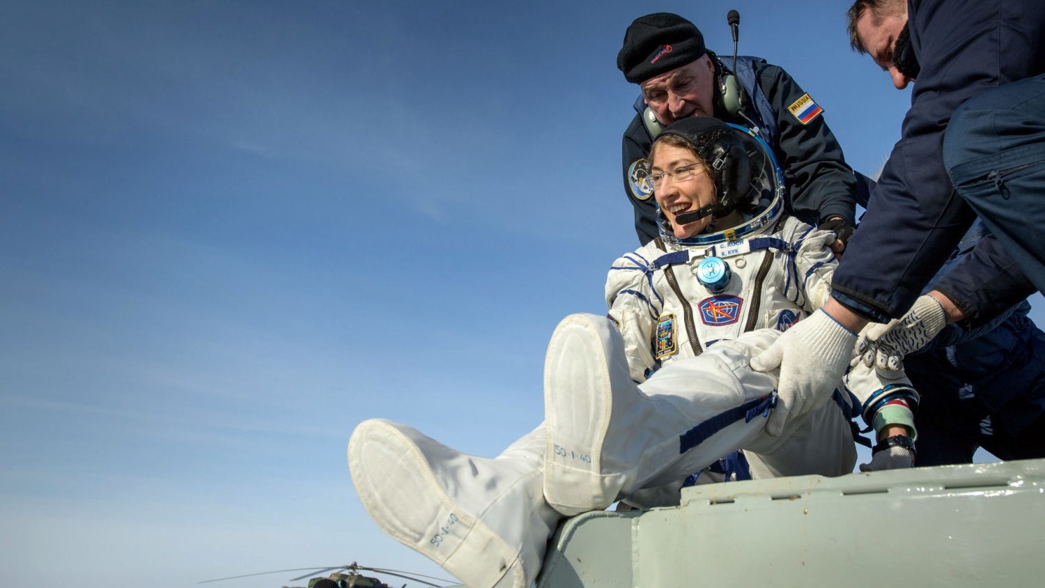 NASA astronaut Christina Koch is helped out of the Soyuz MS-13 spacecraft.