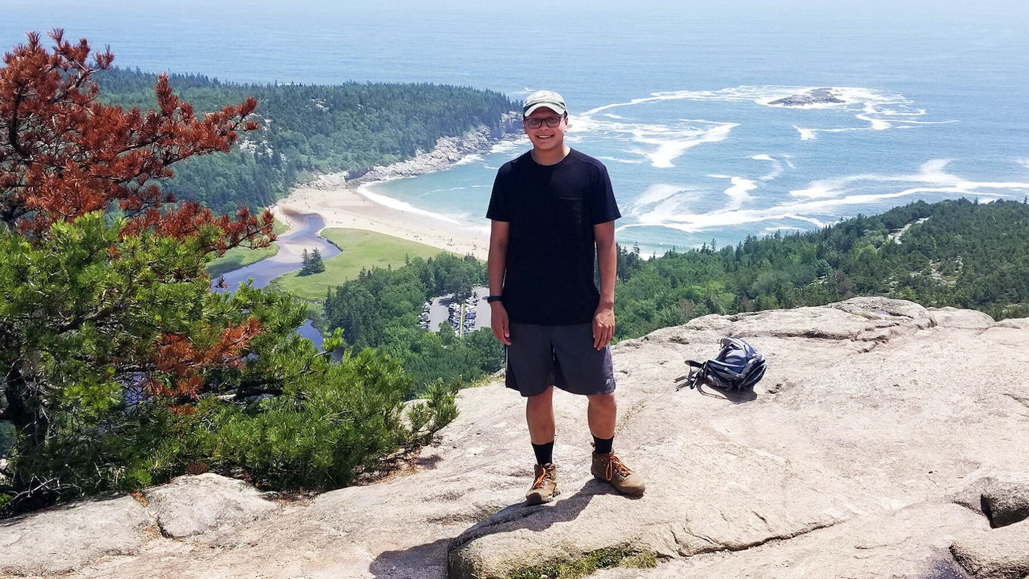 Nikhil Milind standing on a mountain overlooking the ocean