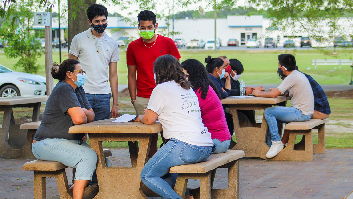 Two Juntos student workers converse with parents at the Sampson Community College Kickoff event this spring