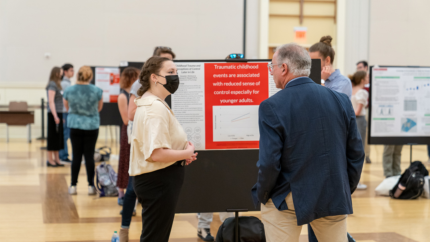 A student presenter talks to Bret Smith, dean of University College