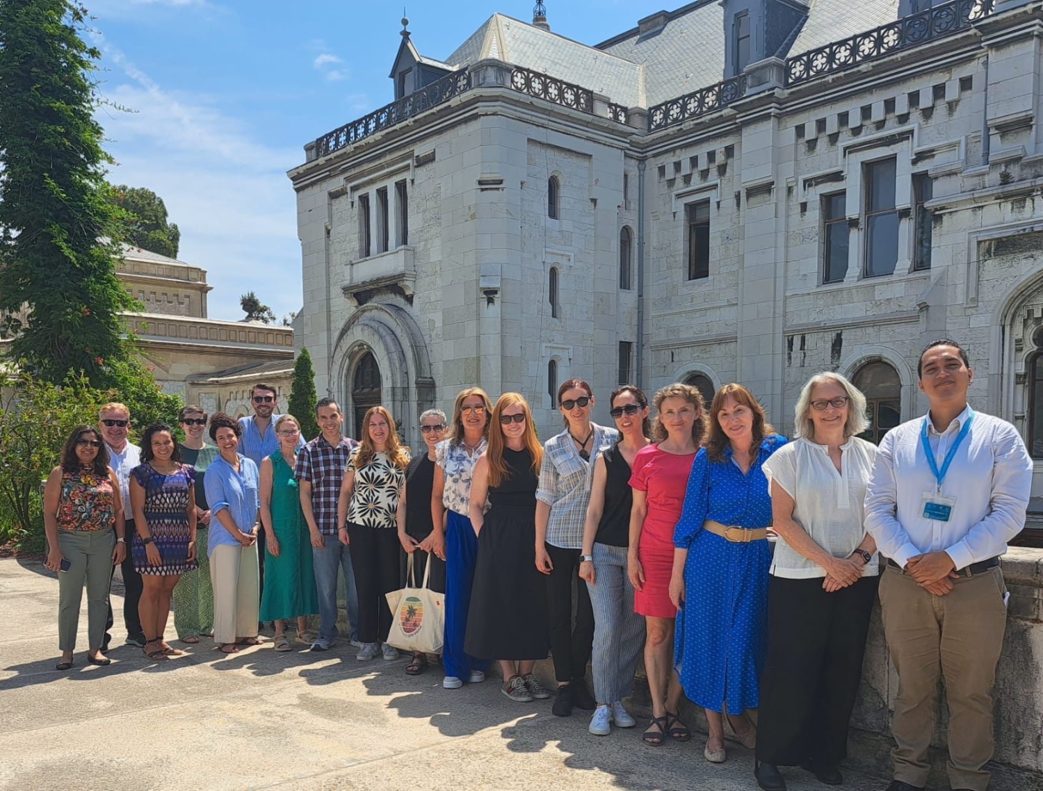 Robert Mera and 17 other people stand for a group photo in front of a French castle, the Valrose Chateau